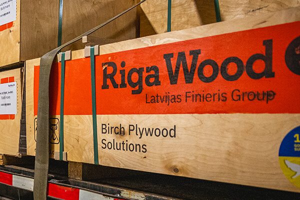 birch plywood on back of flatbed trailer unloading inside a warehouse