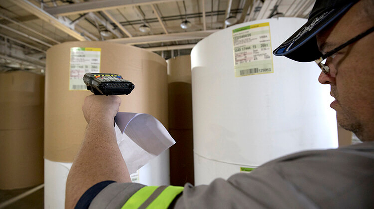 warehouse employee scanning rolls of paper